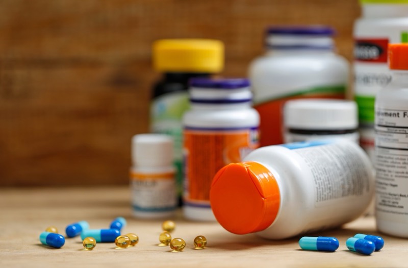 Medicine bottles and tablets arranged on a wooden desk